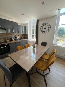 a kitchen with a table and chairs and a clock on the wall at Les Vagues d'Opale in Boulogne-sur-Mer
