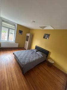 una camera da letto con un letto e una parete gialla di Maison spacieuse à Thun-Saint-Martin avec jardin a Thun-Saint-Martin