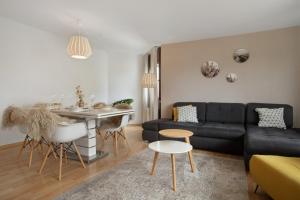 a living room with a black couch and a table at Geräumige schöne Ferienwohnung in Weingarten