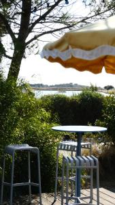 a table and two stools sitting next to a table at Le Phare in Les Portes