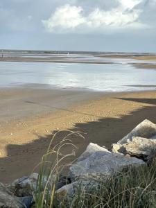a beach with some rocks on the sand and water at La Villa d'Elisa in Saint-Côme-de-Fresné