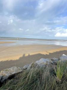 a beach with some rocks and water and the ocean at La Villa d'Elisa in Saint-Côme-de-Fresné +10 photos