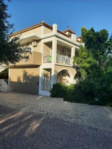 a large house with a driveway in front of it at Rousela apartment in Vasilikos