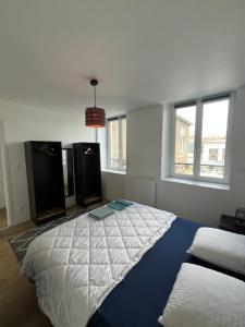 a bedroom with a large bed in a room with windows at Les Vagues d'Opale in Boulogne-sur-Mer