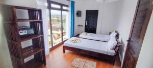 a bedroom with a bed and a large window at HOTEL H1 Fianarantsoa in Fianarantsoa