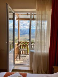 una camera da letto con vista su un balcone con sedia di ANGINE Resort Hotel a Vanadzor