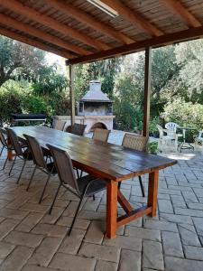 a wooden table and chairs on a patio with a fireplace at Rousela apartment in Vasilikos