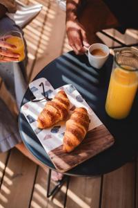 a table with a plate of croissants and a cup of coffee at Le Phare in Les Portes