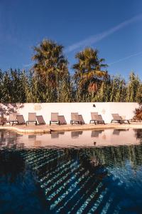 a group of chairs sitting next to a swimming pool at Le Phare in Les Portes