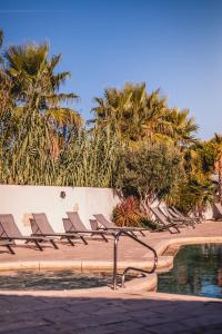 a row of lounge chairs next to a swimming pool at Le Phare in Les Portes