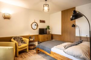 a bedroom with a bed and a chair at Drzewicz Dom Wypoczynkowy in Swornegacie