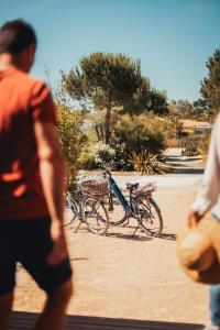 a man walking past two bikes parked in a park at Le Phare in Les Portes