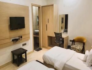 a hotel room with a bed and a television at HOTEL MID-TOWN In Aligarh UP in Alīgarh