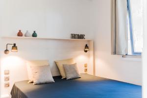 a room with a bed with two pillows and a window at Le Phare in Les Portes