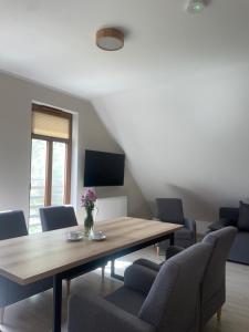 a dining room with a wooden table and chairs at Dom dziedzictwa in Korycin