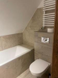 a bathroom with a toilet and a bath tub at Dom dziedzictwa in Korycin +8 photos