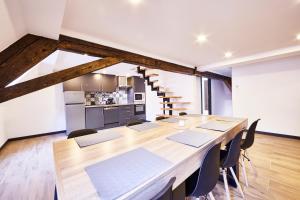 a dining room with a large wooden table and chairs at TH 202 Charmant duplex F4 au 2ème étage - 7 personnes in Thann +28 photos