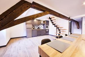 an attic kitchen and dining room with wooden tables and chairs at TH 202 Charmant duplex F4 au 2ème étage - 7 personnes in Thann