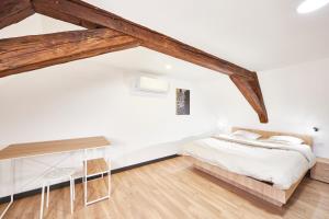 a white bedroom with a bed and a desk at TH 202 Charmant duplex F4 au 2ème étage - 7 personnes in Thann