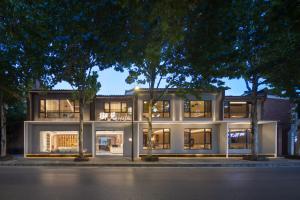 een groot wit gebouw met veel ramen in de nacht bij YujianHotel in Jingdezhen