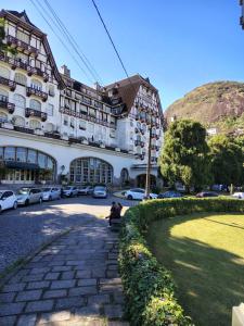 a large building with cars parked in a parking lot at Studio Retrô Palácio Quitandinha in Petrópolis