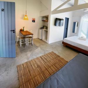 a room with a bed and a table and a bed and a kitchen at Villa Tennis in Ubatuba +27 photos
