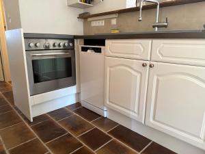 a kitchen with white cabinets and a sink and a stove at Monteur- und Ferienwohnung Ketsch in Ketsch