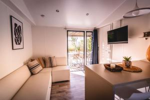 a living room with a couch and a tv at Le Phare in Les Portes