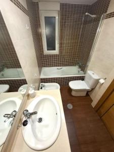 a bathroom with a sink and a toilet at Apartamento Playa Foz in Foz