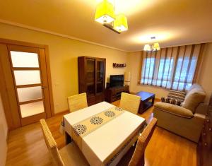 a living room with a table and a couch at Apartamento Playa Foz in Foz