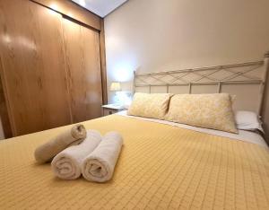 a bedroom with a bed with towels on it at Apartamento Playa Foz in Foz