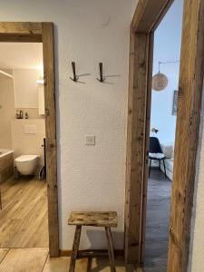 ヴェルビエにあるVerbier cozy Medran ski in ski outのスツールとバスルームのある部屋へのドア