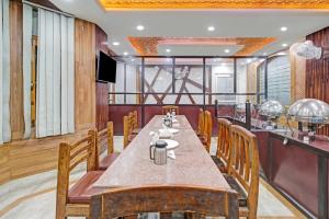 a dining room with a long table and chairs at Hotel O THE HOTEL Oshin Hotel & Restaurant in Srinagar