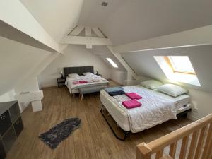a attic bedroom with two beds and a staircase at La Perle de la Côte in Boulogne-sur-Mer