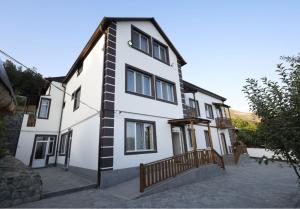 una casa bianca con una recinzione di legno di fronte di ANGINE Resort Hotel a Vanadzor