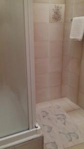 a bathroom with a shower with a glass door at Guesthouse Familija Tariba in Supetarska Draga