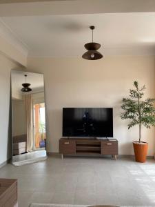 a living room with a flat screen tv on a wall at KL Home- au cœur du centre ville moderne in Marrakech