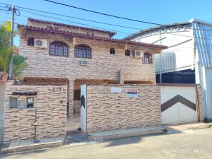 a brick building with a door and a garage at Pousada da Praia Frade in Angra dos Reis
