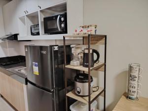 a kitchen with a stainless steel refrigerator and a microwave at 2BR Condo SMDC Charm Metro Manila in Manila