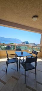 a patio with two tables and chairs and a large window at The Old Town Terrace Apartments in Budva