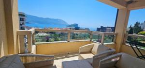 a balcony with chairs and a view of a city at The Old Town Terrace Apartments in Budva