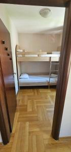 a room with two bunk beds and a wooden floor at The Old Town Terrace Apartments in Budva