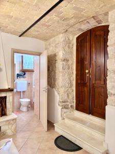 a bathroom with a toilet and a wooden door at Casa Giannetta in Caramanico Terme