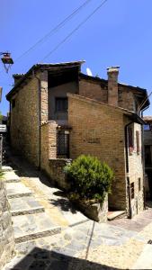 een oud bakstenen gebouw met een struik ervoor bij Residenze del Borgo in Zavattarello