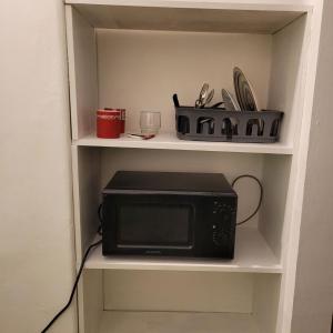 a microwave sitting on a shelf in a kitchen at Central 2 Budget Accomodation in Bucharest