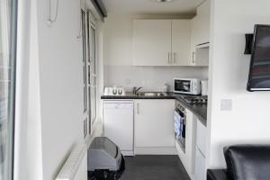 a small kitchen with white cabinets and a sink at Destiny Student – Murano (Campus Accommodation) in Edinburgh