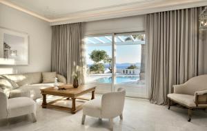 a living room with a couch and a large window at Saint John Hotel Villas & Spa in Agios Ioannis Mykonos