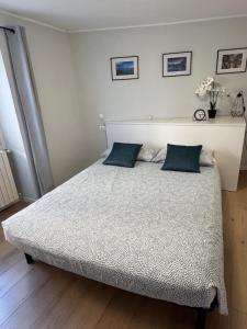 a bedroom with a bed with two blue pillows at Bellano Holidays - Casa Ortensia in Bellano