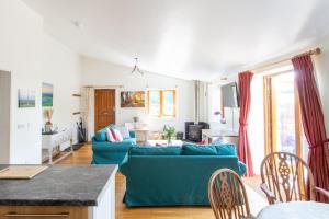a living room with a blue couch and a table at The Croft, Warrens Farm Holidays - Dog friendly in Taunton
