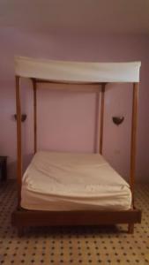 - un lit dans une chambre à baldaquin blanc dans l'établissement Villa elhouda, à Essaouira